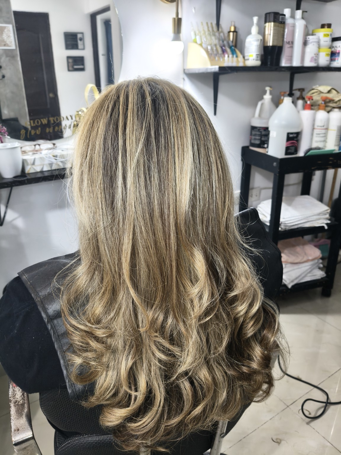 Después del servicio de color: reflejos claros y ondas definidas, visto desde atrás